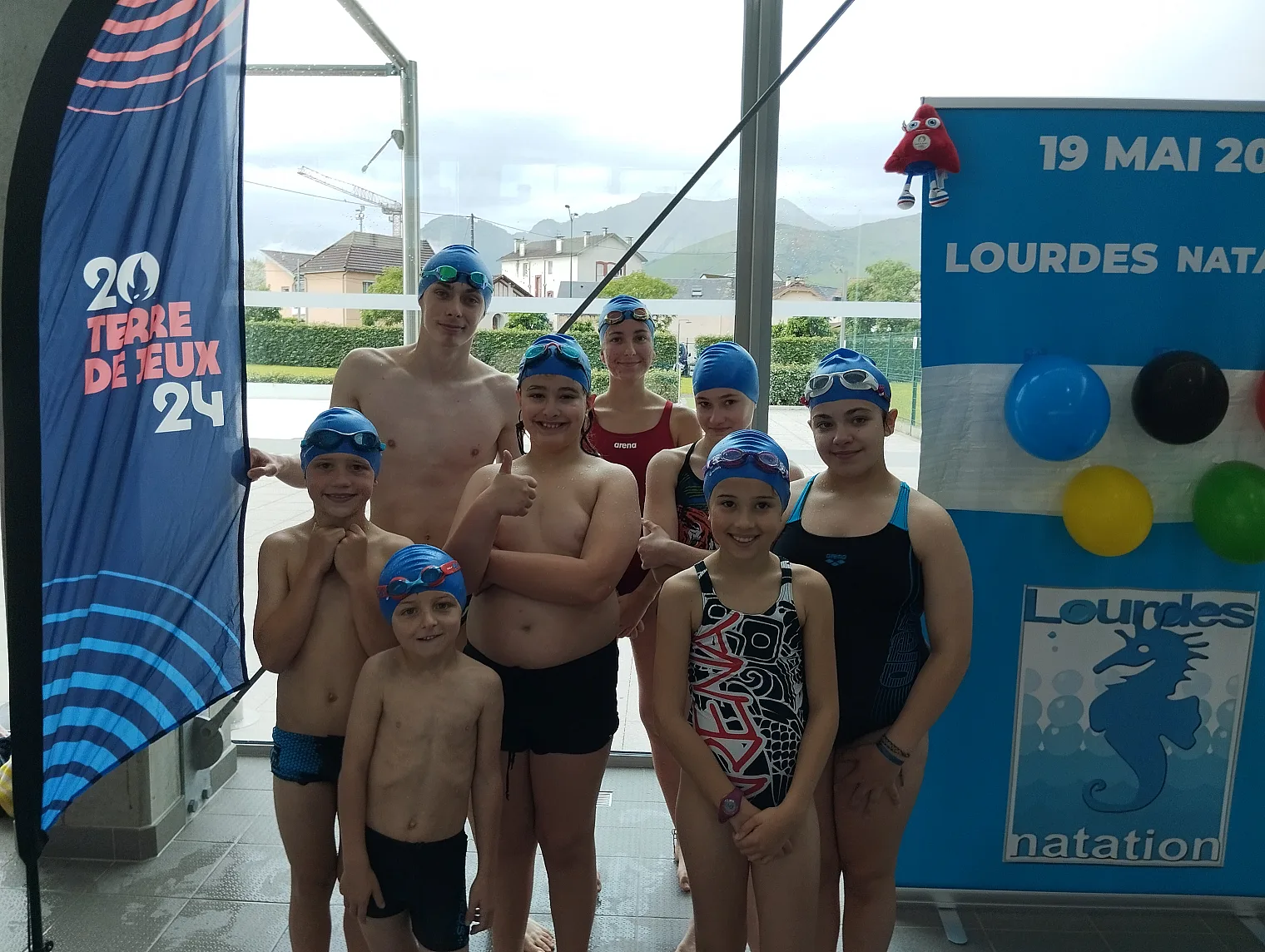 Groupe de nageurs devant l oriflamme Lourdes Natation du 19 mai 2024