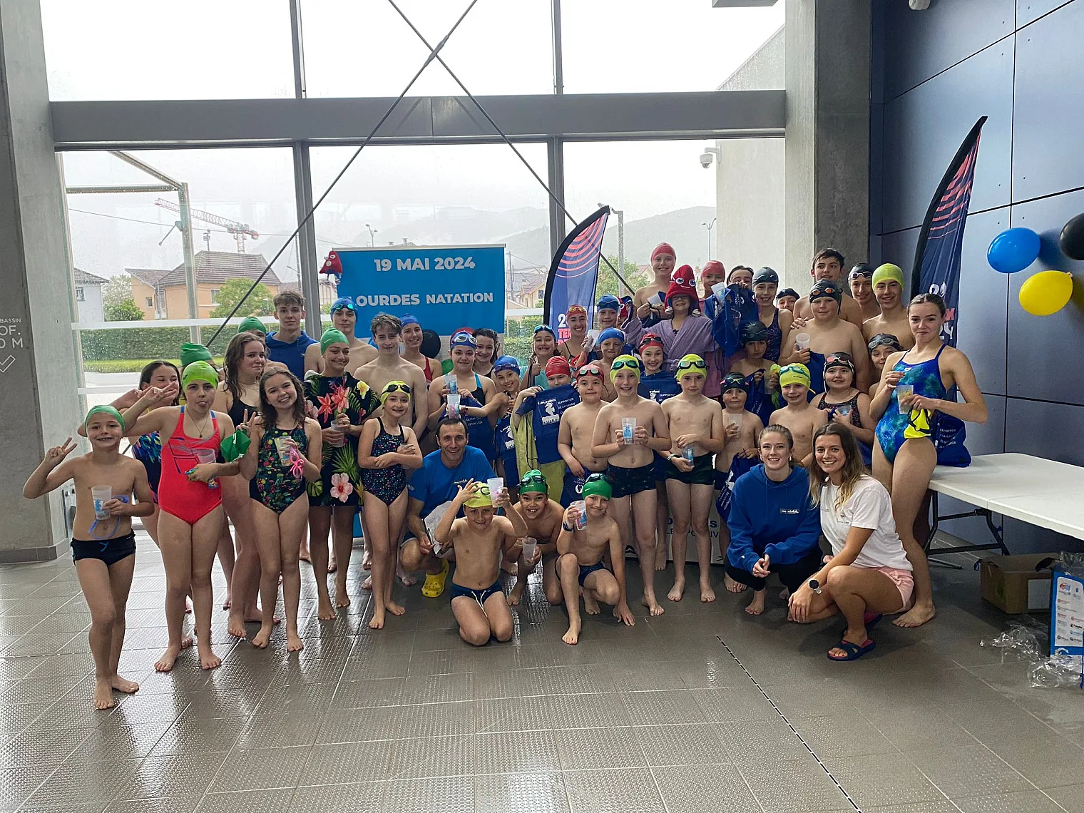 Nageurs et familles rassemblés au complexe aquatique pour le passage de la flamme olympique