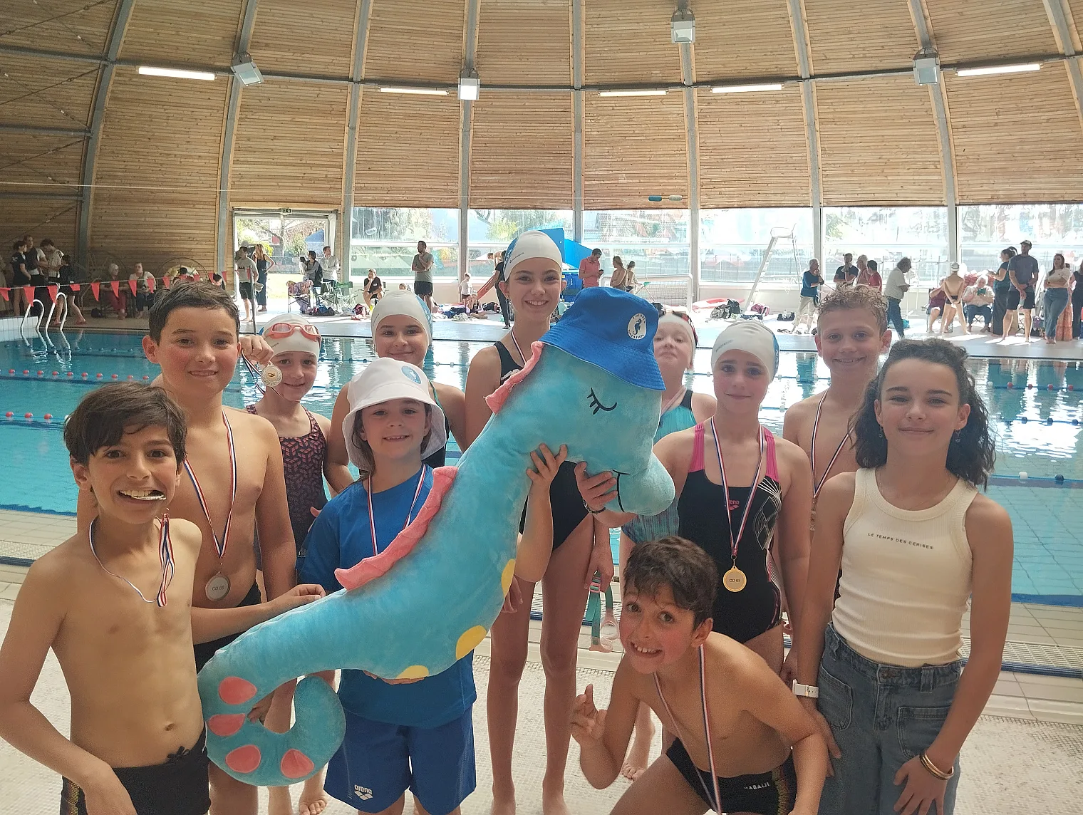 Jeunes nageurs du club posant avec la mascotte hippocampe au bord du bassin, Challenge Avenirs 2026